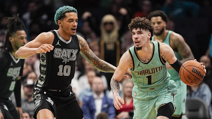 Feb 7, 2025; Charlotte, North Carolina, USA;  Charlotte Hornets guard LaMelo Ball (1) handles the ball defended by San Antonio Spurs forward Jeremy Sochan (10) during the second half at Spectrum Center. Mandatory Credit: Jim Dedmon-Imagn Images