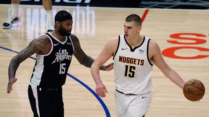 May 1, 2021; Los Angeles, California, USA; Denver Nuggets center Nikola Jokic (15) moves the ball against Los Angeles Clippers center DeMarcus Cousins (15) during the second half at Staples Center. Mandatory Credit: Gary A. Vasquez-Imagn Images