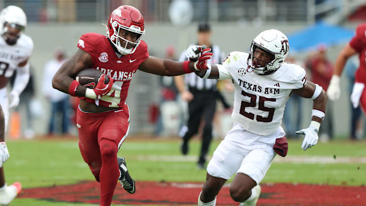 Oct 18, 2025; Fayetteville, Arkansas, USA; Arkansas Razorbacks running back Mike Washington Jr (4) rushes in the second quarter as Texas A&M Aggies safety Dalton Brooks (25) defends at Donald W. Reynolds Razorback Stadium. Mandatory Credit: Nelson Chenault-Imagn Images