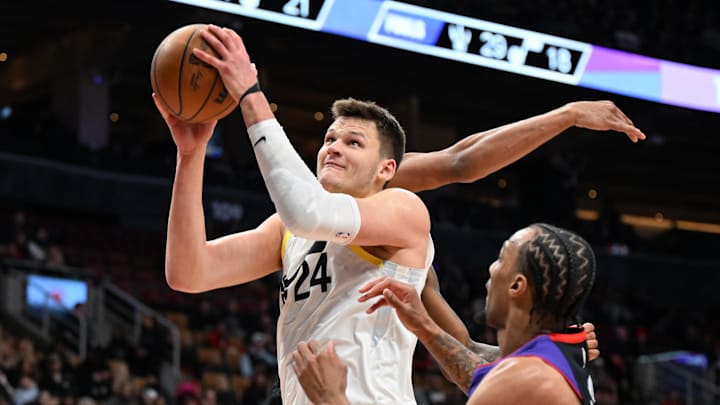 Mar 7, 2025; Toronto, Ontario, CAN;  Utah Jazz center Walker Kessler (24) goes in for a layup over Toronto Raptors guard AJ Lawson (0) in the second half at Scotiabank Arena. Mandatory Credit: Dan Hamilton-Imagn Images