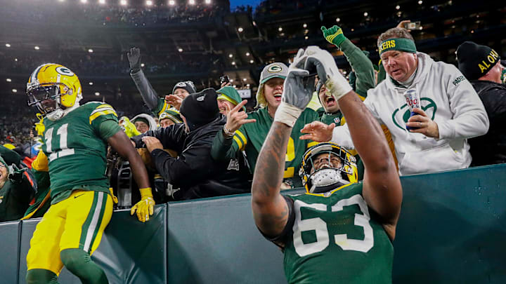 Green Bay Packers offensive tackle Rasheed Walker (63) takes a selfie on a fan’s phone after a touchdown by Josh Jacobs.