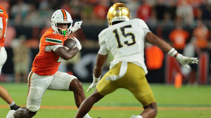 Aug 31, 2025; Miami Gardens, Florida, USA; Miami Hurricanes running back Jordan Lyle (2) rushes the ball against Notre Dame Fighting Irish cornerback Leonard Moore (15) during the second quarter at Hard Rock Stadium. Mandatory Credit: Sam Navarro-Imagn Images