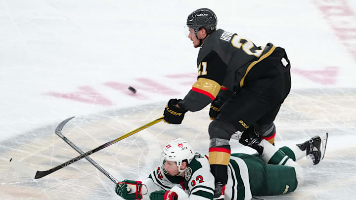 Jan 12, 2025; Las Vegas, Nevada, USA; Vegas Golden Knights center Brett Howden (21) trips up Minnesota Wild center Marco Rossi (23) during the third period at T-Mobile Arena. Mandatory Credit: Stephen R. Sylvanie-Imagn Images