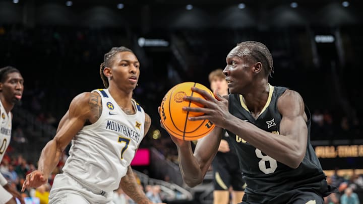 Mar 12, 2025; Kansas City, MO, USA; Colorado Buffaloes forward Bangot Dak (8) drives to the basket around West Virginia Mountaineers guard Javon Small (7) during the second half at T-Mobile Center. Mandatory Credit: William Purnell-Imagn Images