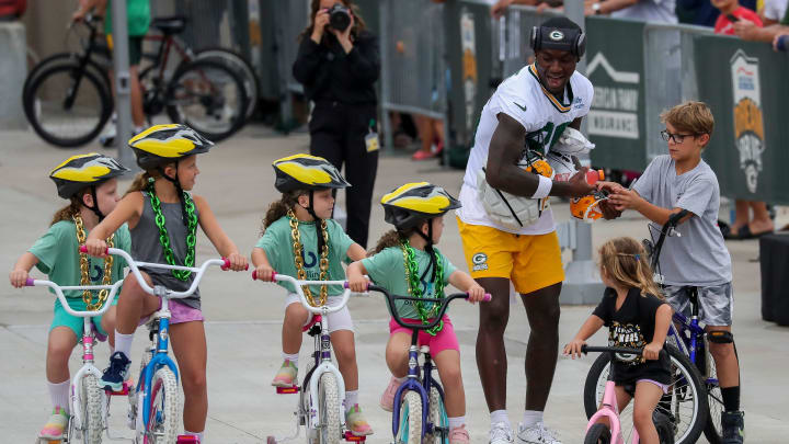 Green Bay Packers receiver Grant DuBose (86) signs an autograph as he’s escorted by a group of young fans at training camp.