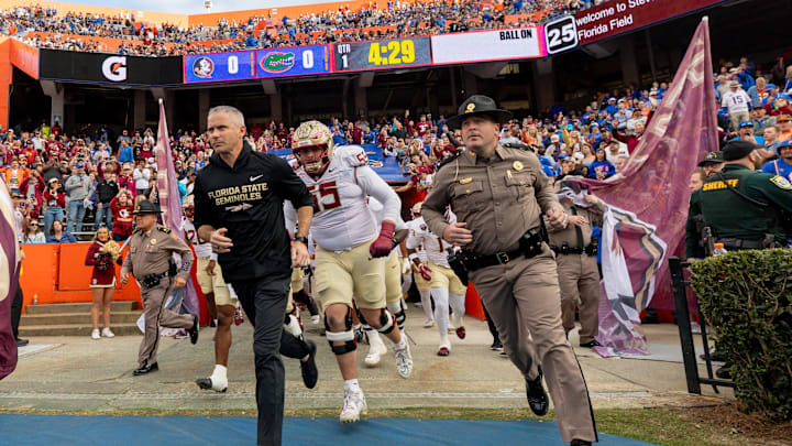 Nov 29, 2025; Gainesville, Florida, USA; Florida State Seminoles head coach Mike Norvell leads his team onto the field before the game against the Florida Gators at Ben Hill Griffin Stadium. Mandatory Credit: Bob Kupbens-Imagn Images