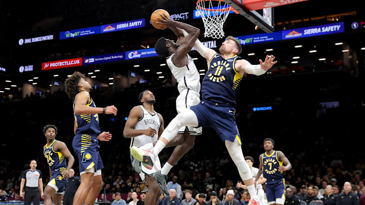 Feb 11, 2026; Brooklyn, New York, USA; Indiana Pacers center Micah Potter (11) fouls Brooklyn Nets guard Drake Powell (4) as he drives to the basket during the second quarter at Barclays Center. 