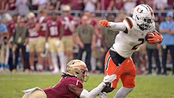 Nov 11, 2023; Tallahassee, Florida, USA; Miami Hurricanes running back Donald Chaney Jr. (2) is tackled by Florida State Seminoles defensive back Akeem Dent (1) at Doak S. Campbell Stadium. Mandatory Credit: Melina Myers-USA TODAY Sports
