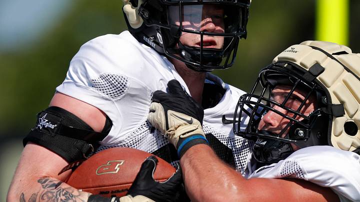 Purdue linebackers Owen Davis (22) and Hudson Miller (40) run a drill.