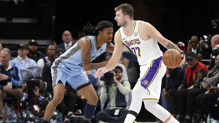 Oct 31, 2025; Memphis, Tennessee, USA; Los Angeles Lakers guard Luka Doncic (77) dribbles as Memphis Grizzlies guard Ja Morant (12) defends during the third quarter at FedExForum. Mandatory Credit: Petre Thomas-Imagn Images