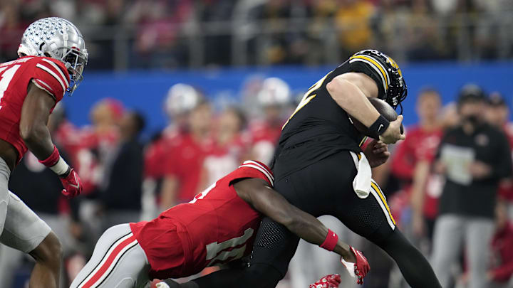 Dec 29, 2023; Arlington, TX, USA; Ohio State Buckeyes cornerback Denzel Burke (10) tackles Missouri Tigers quarterback Brady Cook (12) on a run in the first quarter during the Goodyear Cotton Bowl Classic at AT&T Stadium. Mandatory Credit: Kyle Robertson-USA TODAY Sports
