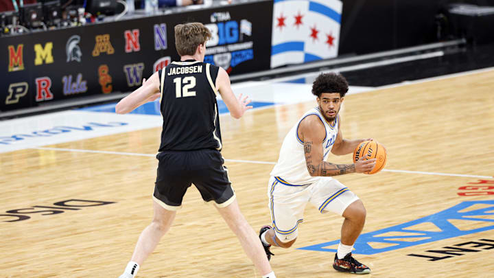 Mar 14, 2026; Chicago, IL, USA; UCLA Bruins guard Eric Freeny (8) brings the ball up court against Purdue Boilermakers center Daniel Jacobsen (12) during the first half at United Center. Mandatory Credit: Kamil Krzaczynski-Imagn Images Mar 14, 2026; Chicago, IL, USA; UCLA Bruins guard Eric Freeny (8) brings the ball up court against Purdue Boilermakers center Daniel Jacobsen (12) during the first half at United Center. Mandatory Credit: Kamil Krzaczynski-Imagn Images