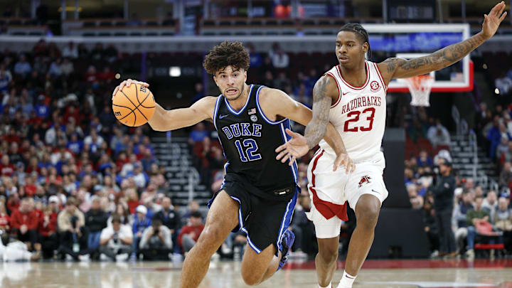 Nov 27, 2025; Chicago, Illinois, USA; Duke Blue Devils forward Cameron Boozer (12) drives to the basket against Arkansas Razorbacks forward Nick Pringle (23) during the second half at United Center. Mandatory Credit: Kamil Krzaczynski-Imagn Images