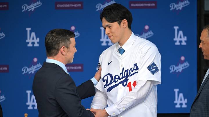 Jan 22, 2025; Los Angeles, CA, USA;  Andrew Friedman, President of baseball operations shakes hands with Los Angeles Dodgers pitcher Roki Sasaki (11) during a press conference at Dodger Stadium. Mandatory Credit: Jayne Kamin-Oncea-Imagn Images  