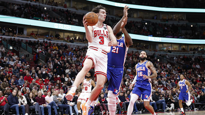  Chicago Bulls guard Josh Giddey (3)passes the ball against Philadelphia 76ers center Joel Embiid (21) during the first half at United Center. Mandatory Credit: Kamil Krzaczynski-Imagn Images