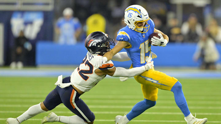 Chargers wide receiver Ladd McConkey (15) avoids a tackle by Broncos safety Brandon Jones (22) in 2024. Chargers wide receiver Ladd McConkey (15) avoids a tackle by Broncos safety Brandon Jones (22) in 2024.