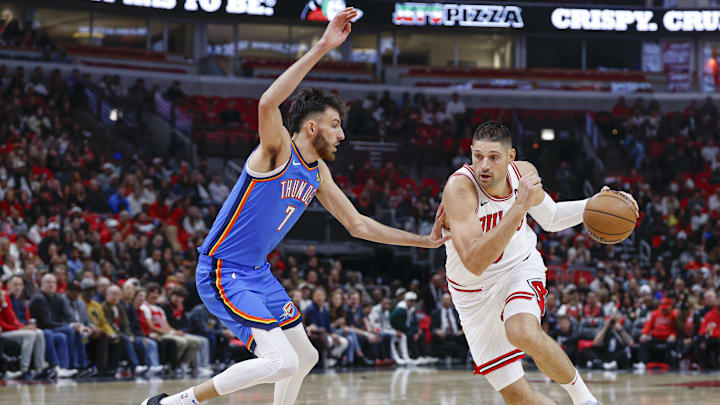 Oct 26, 2024; Chicago, Illinois, USA; Chicago Bulls center Nikola Vucevic (9) drives to the basket against Oklahoma City Thunder forward Chet Holmgren (7) during the first half at United Center. Mandatory Credit: Kamil Krzaczynski-Imagn Images