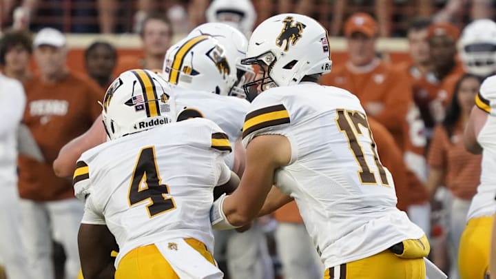 Sep 16, 2023; Austin, Texas, USA; Wyoming Cowboys quarterback Evan Svoboda (17) hands off to running back Harrison Waylee (4) before running for a touchdown in the first half against the Texas Longhorns at Darrell K Royal-Texas Memorial Stadium. Mandatory Credit: Scott Wachter-Imagn Images