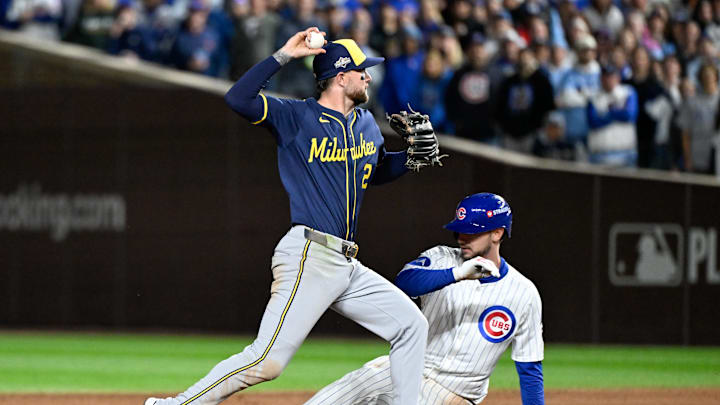 Oct 8, 2025; Chicago, Illinois, USA; Chicago Cubs designated hitter Kyle Tucker (30) is out at second base as Milwaukee Brewers second baseman Brice Turang (2) throws to first base in the seventh inning during game three of the NLDS round for the 2025 MLB playoffs at Wrigley Field. Mandatory Credit: Matt Marton-Imagn Images