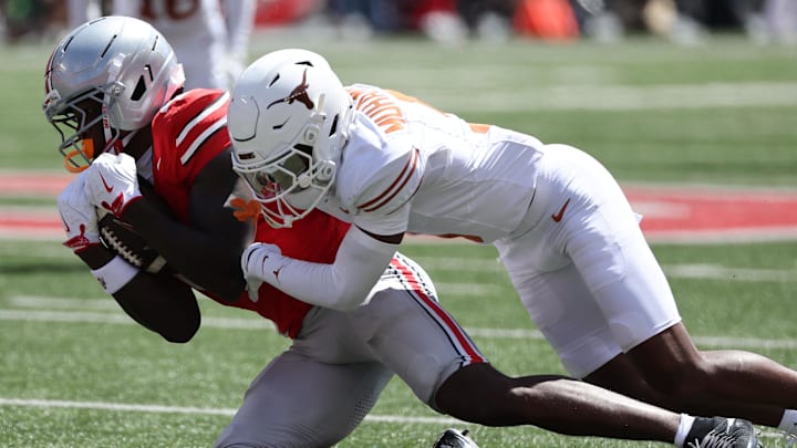 Aug 30, 2025; Columbus, Ohio, USA; Ohio State Buckeyes wide receiver Jeremiah Smith (4) makes a catch over Texas Longhorns defensive back Malik Muhammad (5) in the first half at Ohio Stadium. Mandatory Credit: Joseph Maiorana-Imagn Images