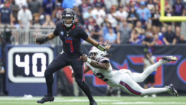 Oct 6, 2024; Houston, Texas, USA; Houston Texans quarterback C.J. Stroud (7) runs with the ball as Buffalo Bills linebacker Dorian Williams (42) attempts to make a tackle during the fourth quarter at NRG Stadium. Mandatory Credit: Troy Taormina-Imagn Images
