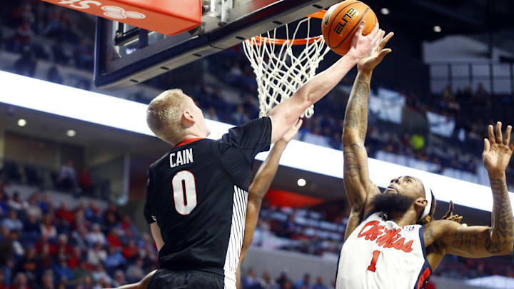 Jan 4, 2025; Oxford, Mississippi, USA; Georgia Bulldogs guard Blue Cain (0) shoots as Mississippi Rebels forward Mikeal Brown-Jones (1) defends during the first half at The Sandy and John Black Pavilion at Ole Miss. Mandatory Credit: Petre Thomas-Imagn Images