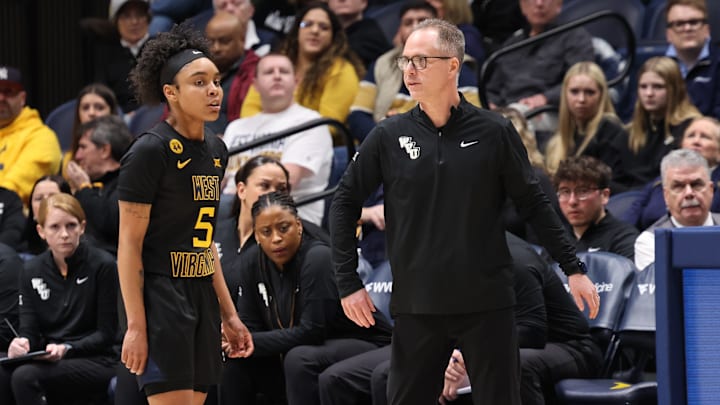 West Virginia University head coach Mark Kellogg giving instruction to guard Sydney Shaw.