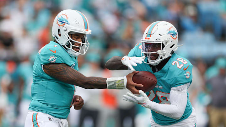 Miami Dolphins quarterback Tua Tagovailoa (1) hands off the ball to Miami Dolphins running back De'Von Achane (28) during the first quarter against the Carolina Panthers at Bank of America Stadium. 