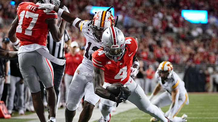 Ohio State Buckeyes wide receiver Jeremiah Smith (4) gets a block from wide receiver Carnell Tate (17) on Minnesota Golden Gophers defensive back Darius Green (12) during the NCAA football game at Ohio Stadium in Columbus on Oct. 4, 2025.