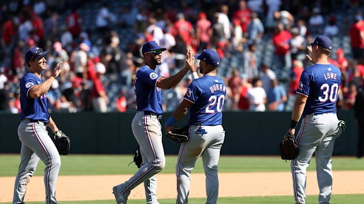 Sep 29, 2024; Anaheim, California, USA;  Texas Rangers left fielder Wyatt Langford (36) and center fielder Leody Taveras (3) and third baseman Ezequiel Duran (20) and first baseman Nathaniel Lowe (30) celebrate after defeating the Los Angeles Angels 8-0 at Angel Stadium. 