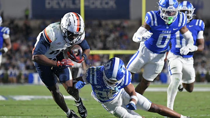 Nov 15, 2025; Durham, North Carolina, USA; Virginia Cavaliers wide receiver Trell Harris (11) takes a hit from Duke Blue Devils saftey Ma'khi Jones (26) during the third quarter at Wallace Wade Stadium. Mandatory Credit: Zachary Taft-Imagn Images Nov 15, 2025; Durham, North Carolina, USA; Virginia Cavaliers wide receiver Trell Harris (11) takes a hit from Duke Blue Devils saftey Ma'khi Jones (26) during the third quarter at Wallace Wade Stadium. Mandatory Credit: Zachary Taft-Imagn Images