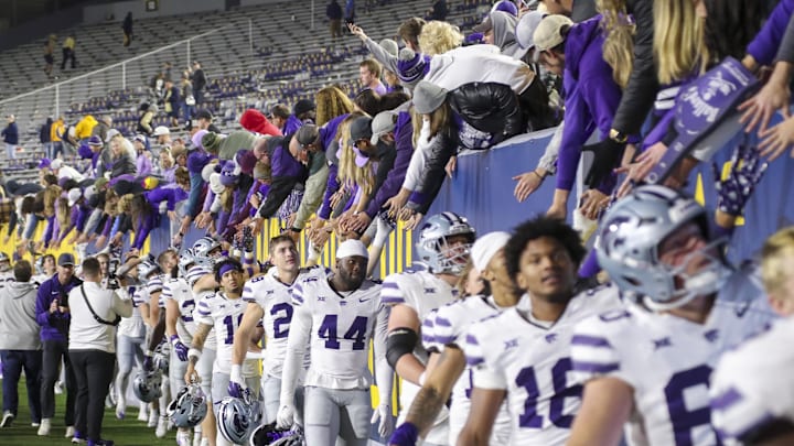 Oct 19, 2024; Morgantown, West Virginia, USA; Kansas State Wildcats players celebrate with fans after defeating the West Virginia Mountaineers at Mountaineer Field at Milan Puskar Stadium. Mandatory Credit: Ben Queen-Imagn Images
