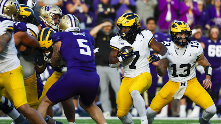 Oct 5, 2024; Seattle, Washington, USA; Michigan Wolverines running back Donovan Edwards (7) takes a hand off from quarterback Jack Tuttle (13) to rush for a touchdown against the Washington Huskies during the second quarter at Alaska Airlines Field at Husky Stadium. Mandatory Credit: Joe Nicholson-Imagn Images Oct 5, 2024; Seattle, Washington, USA; Michigan Wolverines running back Donovan Edwards (7) takes a hand off from quarterback Jack Tuttle (13) to rush for a touchdown against the Washington Huskies during the second quarter at Alaska Airlines Field at Husky Stadium. Mandatory Credit: Joe Nicholson-Imagn Images