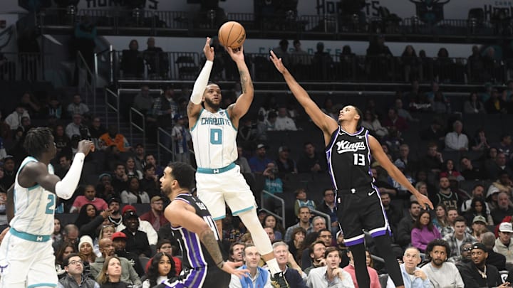 Jan 10, 2024; Charlotte, North Carolina, USA; Charlotte Hornets forward Miles Bridges (0) shoots past the defense of Sacramento Kings forward Keegan Murray (13) during the second half at the Spectrum Center. Mandatory Credit: Sam Sharpe-Imagn Images