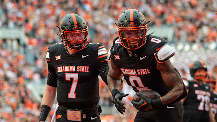 Nov 2, 2024; Stillwater, Oklahoma, USA; Oklahoma State Cowboys running back Ollie Gordon II (0) and Oklahoma State Cowboys quarterback Alan Bowman (7) celebrate in the end zone after a touchdown during the second quarter against the Arizona State Sun Devils at Boone Pickens Stadium. Mandatory Credit: William Purnell-Imagn Images Nov 2, 2024; Stillwater, Oklahoma, USA; Oklahoma State Cowboys running back Ollie Gordon II (0) and Oklahoma State Cowboys quarterback Alan Bowman (7) celebrate in the end zone after a touchdown during the second quarter against the Arizona State Sun Devils at Boone Pickens Stadium. Mandatory Credit: William Purnell-Imagn Images