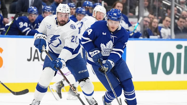 Jan 20, 2025; Toronto, Ontario, CAN; Toronto Maple Leafs center Bobby McMann (74) skates with the puck as Tampa Bay Lightning left wing Nick Paul (20) gives chase during the second period at Scotiabank Arena. Mandatory Credit: Nick Turchiaro-Imagn Images