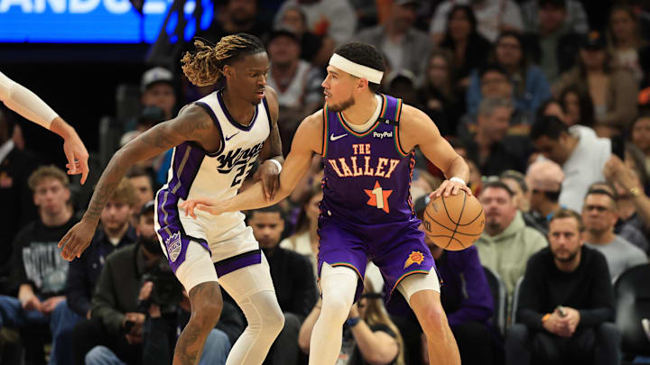 Mar 14, 2025; Phoenix, Arizona, USA; Phoenix Suns guard Devin Booker (1) against Sacramento Kings guard Keon Ellis (23) at Footprint Center. Mandatory Credit: Mark J. Rebilas-Imagn Images