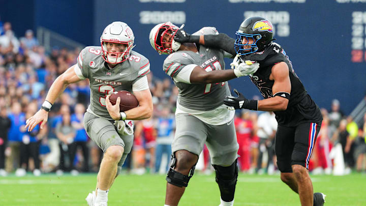 Sep 13, 2024; Kansas City, Kansas, USA; UNLV Rebels quarterback Matthew Sluka (3) runs the ball against Kansas Jayhawks defensive end Dean Miller (45) during the first half at Children's Mercy Park. Mandatory Credit: Jay Biggerstaff-Imagn Images