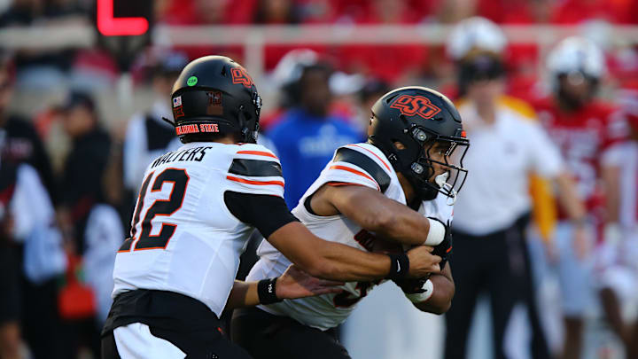 Oct 25, 2025; Lubbock, Texas, USA;  Oklahoma State Cowboys quarterback Noah Walters (12) hands the ball to running back Sesi Vailahi (3) in the second half during the game against the Texas Tech Red Raiders at Jones AT&T Stadium. Mandatory Credit: Michael C. Johnson-Imagn Images