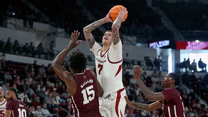 Arkansas Razorbacks forward Trevon Brazile (7) drives to the basket between Mississippi State Bulldogs center Quincy Ballard (15) and guard Shawn Jones Jr. (5) during the first half at Humphrey Coliseum.