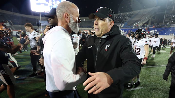 Jan 2, 2026; Memphis, TN, USA; Navy Midshipmen head coach Brian Newberry shakes hands with Cincinnati Bearcats head coach Scott Satterfield after the Liberty Bowl  at Simmons Bank Liberty Stadium. Mandatory Credit: Petre Thomas-Imagn Images