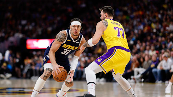 Jan 20, 2026; Denver, Colorado, USA; Denver Nuggets forward Aaron Gordon (32) controls the ball as Los Angeles Lakers guard Luka Doncic (77) guards in the first quarter at Ball Arena. Mandatory Credit: Isaiah J. Downing-Imagn Images