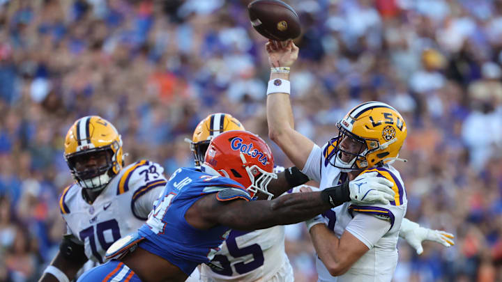 Nov 16, 2024; Gainesville, Florida, USA; LSU Tigers quarterback Garrett Nussmeier (13) throws the ball as Florida Gators edge George Gumbs Jr. (34) pressures during the first half at Ben Hill Griffin Stadium. Mandatory Credit: Kim Klement Neitzel-Imagn Images