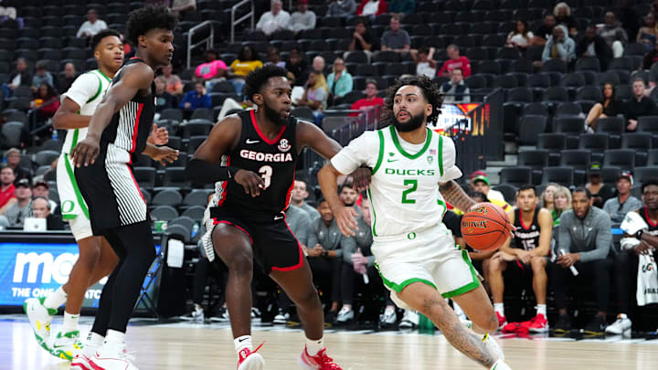 Nov 6, 2023; Las Vegas, Nevada, USA; Oregon Ducks guard Jesse Zarzuela (2) dribbles around Georgia Bulldogs guard Noah Thomasson (3) during the first half at T-Mobile Arena. Mandatory Credit: Stephen R. Sylvanie-Imagn Images Nov 6, 2023; Las Vegas, Nevada, USA; Oregon Ducks guard Jesse Zarzuela (2) dribbles around Georgia Bulldogs guard Noah Thomasson (3) during the first half at T-Mobile Arena. Mandatory Credit: Stephen R. Sylvanie-Imagn Images