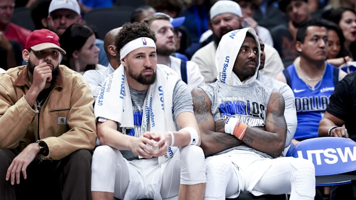 Dallas Mavericks guard Kyrie Irving and Dallas Mavericks guard Klay Thompson react on the bench.