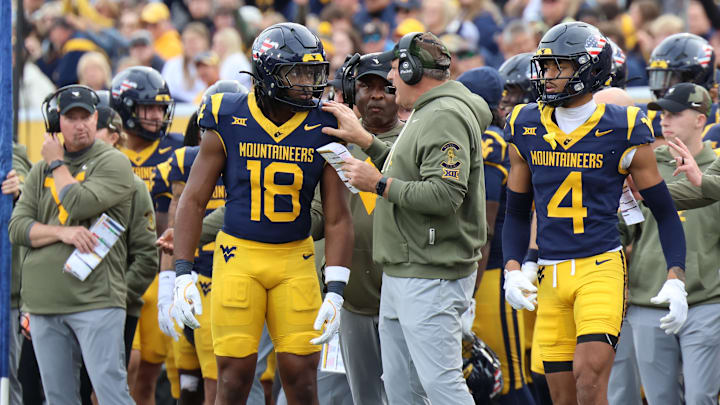 West Virginia University head coach Rich Rodriguez giving instructions to Bandit/running back Curtis Jones Jr. against Colorado.