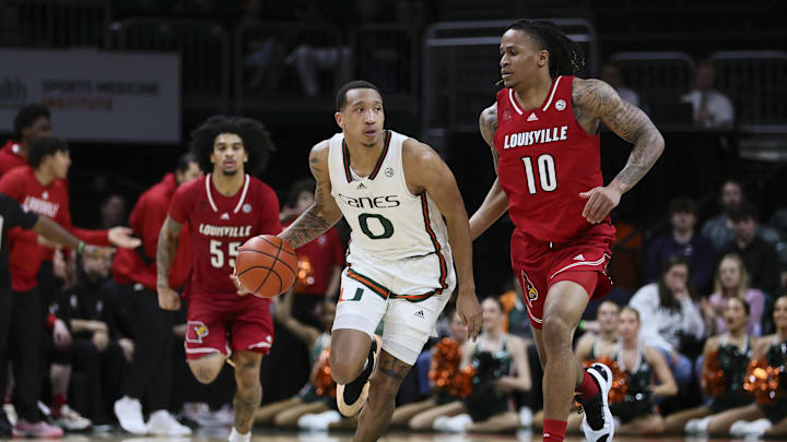 Jan 10, 2024; Coral Gables, Florida, USA; Miami Hurricanes guard Matthew Cleveland (0) dribbles the basketball ahead of Louisville Cardinals forward Kaleb Glenn (10) during the second half at Watsco Center. Mandatory Credit: Sam Navarro-Imagn Images