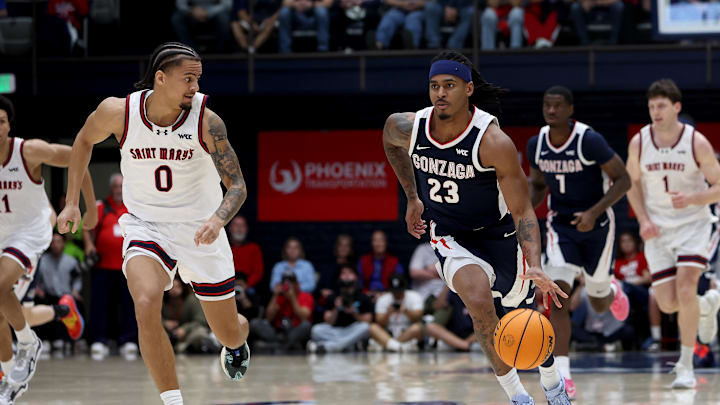 Feb 28, 2026; Moraga, California, USA; Gonzaga Bulldogs guard Adam Miller (23) dribbles past St. Mary's Gaels guard Mikey Lewis (0) during the first half at University Credit Union Pavilion.
