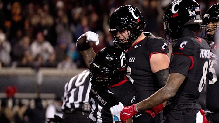 Nov 30, 2024; Cincinnati, Ohio, USA; Cincinnati Bearcats running back Corey Kiner (21) celebrates with offensive lineman Gavin Gerhardt (53) after scoring a touchdown against the TCU Horned Frogs in the second quarter at Nippert Stadium. Mandatory Credit: Albert Cesare/USA TODAY Network via Imagn Images Nov 30, 2024; Cincinnati, Ohio, USA; Cincinnati Bearcats running back Corey Kiner (21) celebrates with offensive lineman Gavin Gerhardt (53) after scoring a touchdown against the TCU Horned Frogs in the second quarter at Nippert Stadium. Mandatory Credit: Albert Cesare/USA TODAY Network via Imagn Images