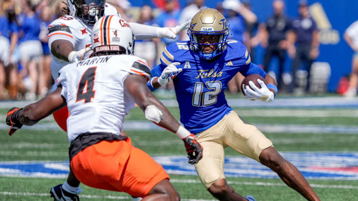 Tulsa wide receiver Corey Smith (12) receives and runs the ball in the first half during an NCAA football game